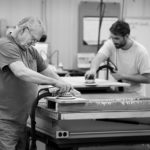 men sanding wooden table tops Made in America factory