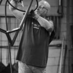 man cleaning steel table frame factory made in America